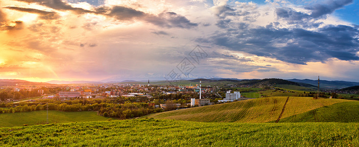 山谷绿色田野里的城镇美丽的春天日落城市的山上全景图片