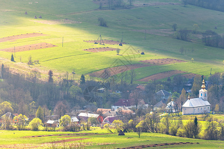 阳光明媚的春天青山谷的教堂村庄美丽的春天景观图片