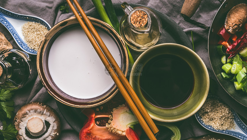 碗与椰奶,酱油,芝麻油,筷子蔬菜厨房的桌子背景,顶部视图亚洲食品烹饪原料,中国泰国菜的图片