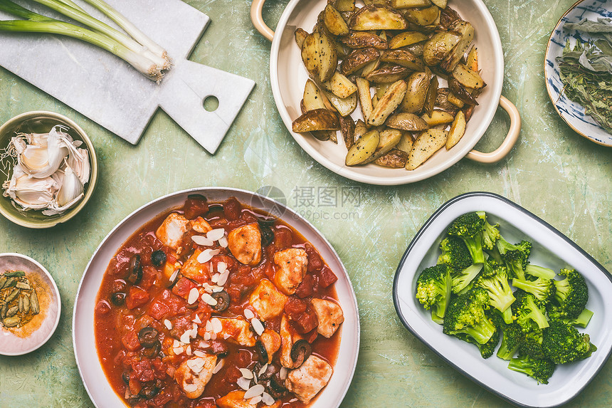 健康平衡的饮食观念锅与鸡肉片西红柿酱,绿色煮熟的西兰花烤土豆厨房的桌子背景,顶部视图图片