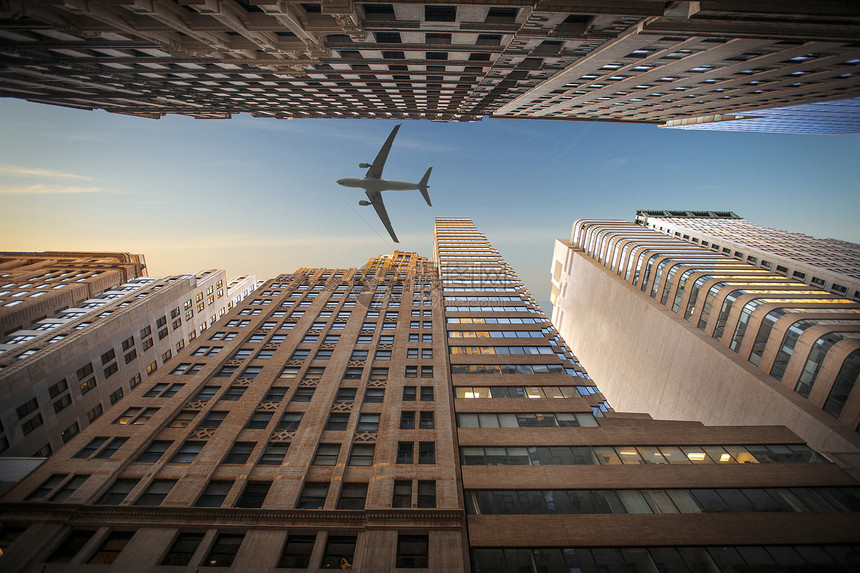 这架飞机低空飞越纽约曼哈顿天际线,usa五颜六色的日落纽约市曼哈顿天际线,usa图片