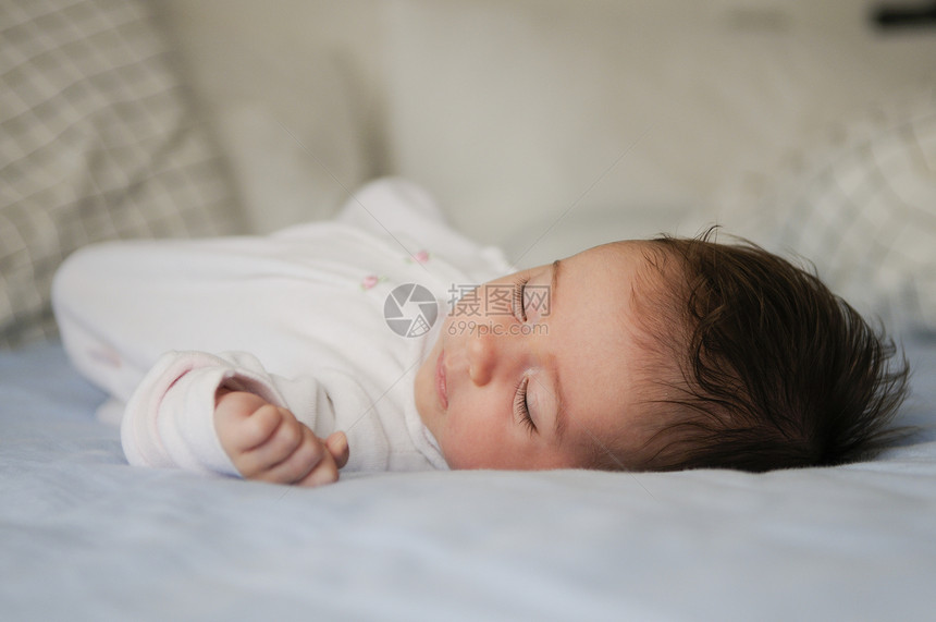 新生儿家里睡蓝色床单上图片