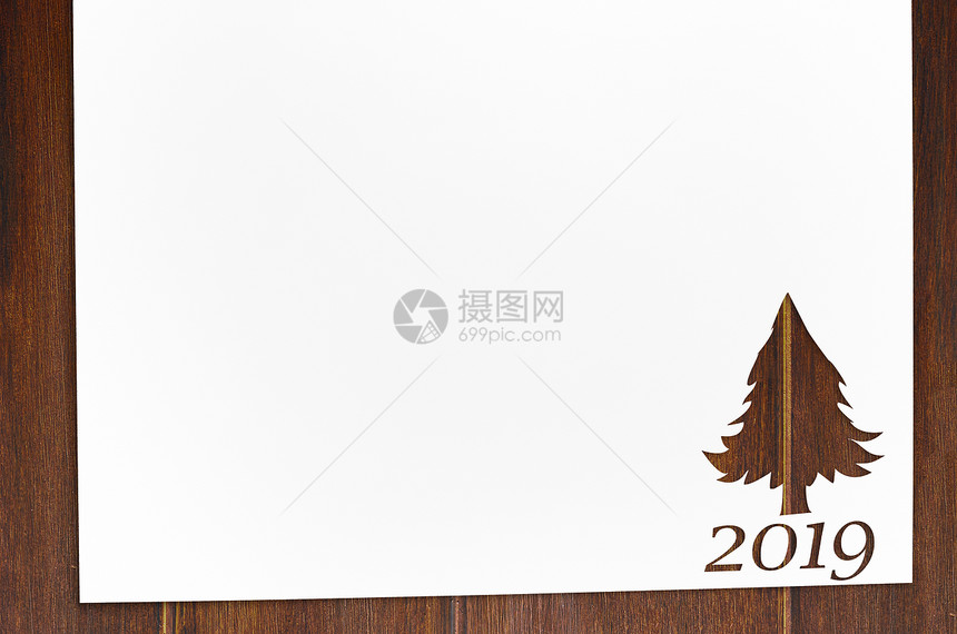 为2019诞卡木制桌子上的新背景剪下杉木树形状的纸桌子上用冷杉树形状切纸图片