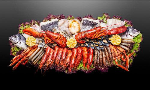 黑色背景上盘子上的海洋食品的创意照片背景图片
