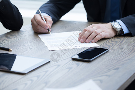 商务人员会议上桌子上签合同商人签订合同图片