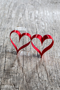 两颗红色丝带的心木制的背,情人节的两颗丝带木头上图片
