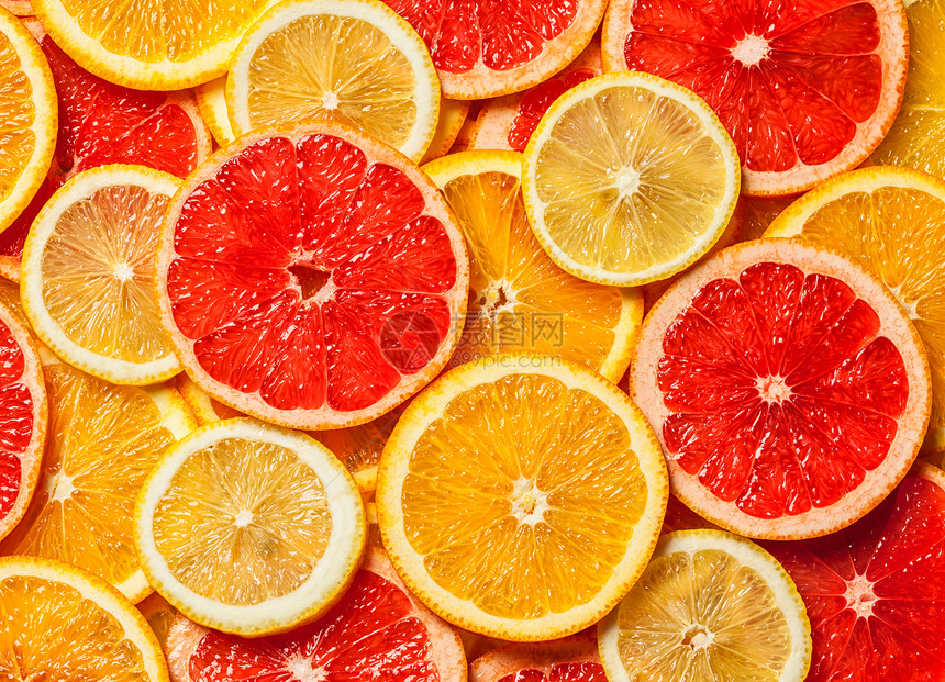 彩色柑橘类水果柠檬,橘子,柚子片背景五颜六色的柑橘类水果片图片