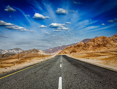 前进的背景喜马拉雅山的道路与山脉戏剧的云拉达克,查谟克什米尔,喜马拉雅山脉的道路地平线高清图片素材