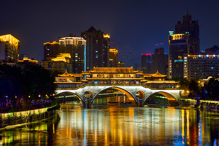 成都著名的地标安顺桥金河上,夜间照明与现代摩天大楼的背景,成都,四川,中国安顺桥夜间城市景观高清图片素材