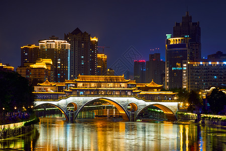 成都著名的地标安顺桥金河上,夜间照明与现代摩天大楼的背景,成都,四川,中国安顺桥夜间,中国城市的高清图片素材