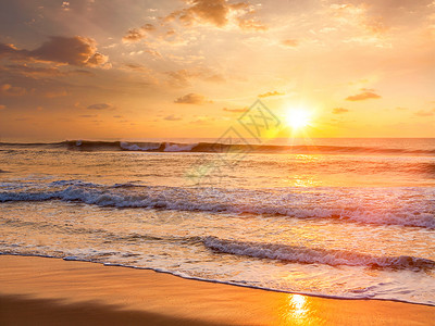 日出与朝阳早晨的海滩上镜头耀斑光泄漏海滩上的日出图片