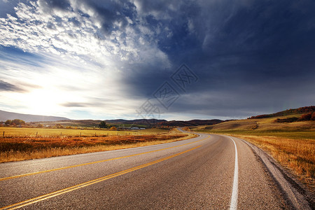 阳光明媚的早晨,乡间道路上五彩缤纷的秋天景象高清图片