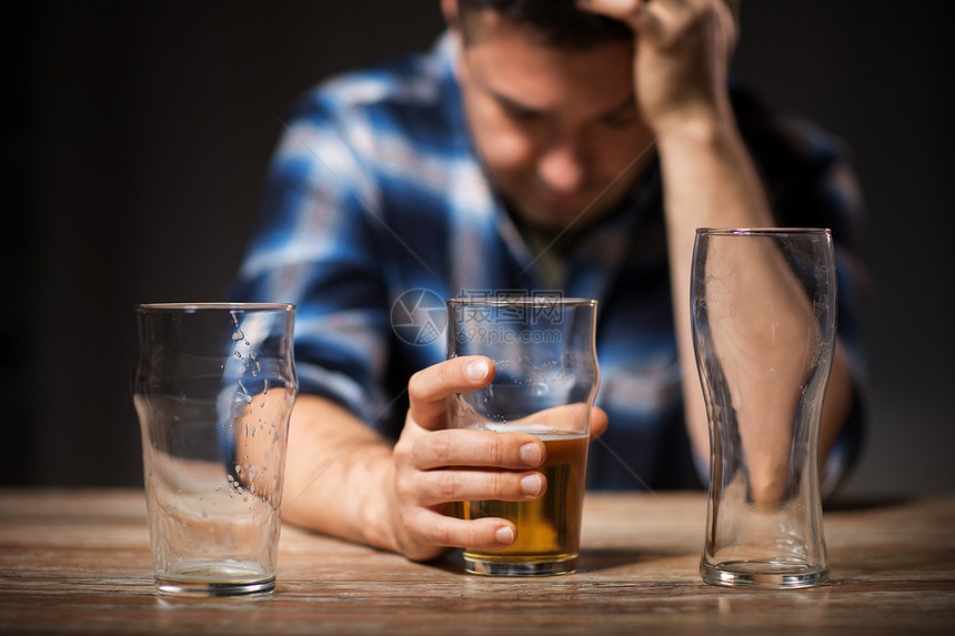 酒精中,酒精成瘾人们的男酒精饮料啤酒璃晚上晚上用璃杯喝啤酒图片