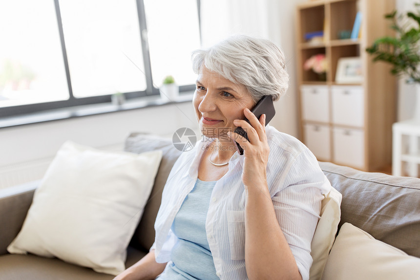 技术,沟通人的快乐的老年女子打电话家里智能手机老妇女家里打电话给智能手机图片
