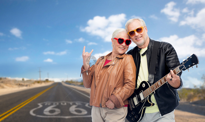 滚音乐,老旅游快乐的老夫妇与电吉他们的路线66背景老夫妇带着电吉他66号公路上图片