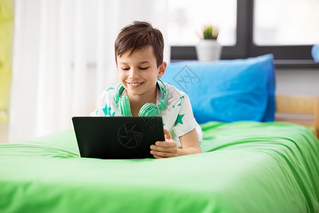 童,技术人的男孩与平板电脑电脑玩游戏家里男孩家里玩平板电脑电脑游戏图片
