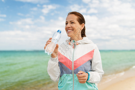 健身,运动健康的生活方式妇女海滩锻炼后饮水女人海滩上锻炼后喝水图片