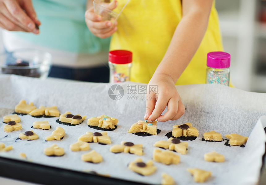家庭,烹饪烘焙母亲小女儿家庭厨房的托盘上装饰饼干母亲女儿家饼干图片