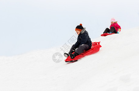 童,雪橇季节快乐的孩子们冬天乘雪橇滑下雪山快乐的孩子们冬天乘雪橇下山背景图片