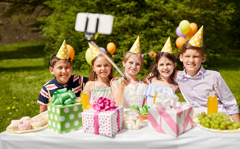 生日拍照假期,童技术快乐的孩子拍照自拍杆生日聚会夏季花园快乐的孩子生日聚会上自拍背景