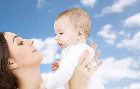家庭母亲的快乐的微笑轻母亲与小婴儿天空背景妈妈带着孩子天空背景上图片