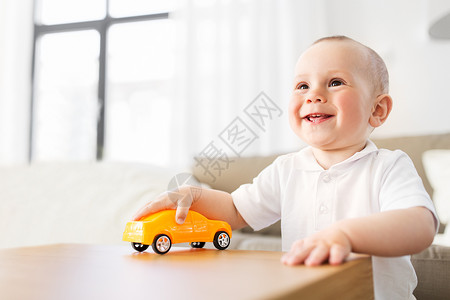 小孩玩具车童人们的快乐的小男孩家里玩玩具车快乐的小男孩家玩玩具车背景