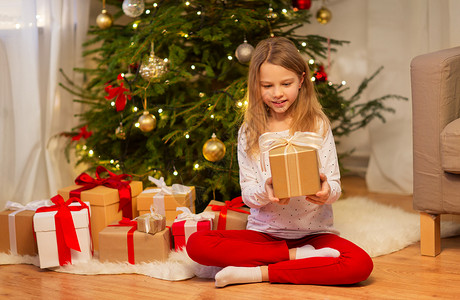 诞节,假期童的微笑的女孩与礼品盒家里微笑的女孩带着诞礼物家背景图片