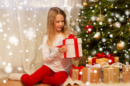 诞节,假期童的微笑的女孩与礼品盒家里微笑的女孩带着诞礼物家背景图片
