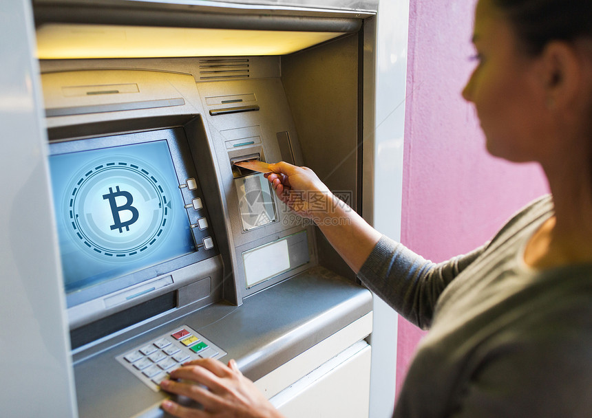 金融,加密货币技术密切妇女手插入银行卡ATM机与比特币图标屏幕上妇女插入卡ATM机图片