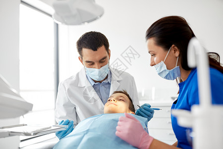 ,牙科医疗保健牙科医生与口腔镜探头检查儿童牙齿图片