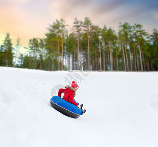 冬天,休闲娱乐活动的快乐的十几岁女孩滑下雪管下山快乐的少女雪管上滑下山背景图片