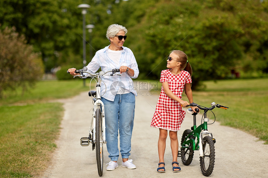 家庭,休闲人的快乐的祖母孙女与自行车夏季公园祖母孙女骑自行车图片