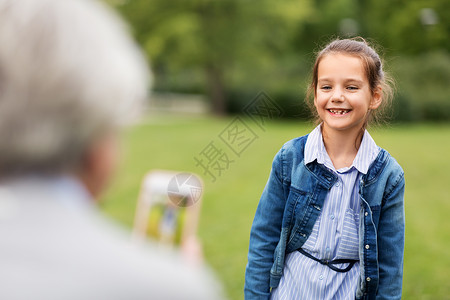 家庭,休闲技术快乐的小女孩被拍照夏季公园小女孩夏天公园被拍照图片