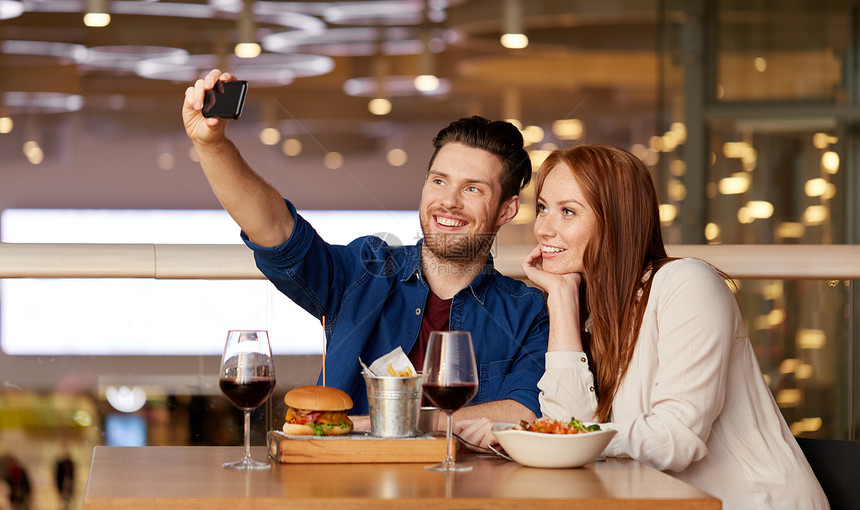 休闲,技术人的快乐的夫妇餐厅吃午饭用智能手机自拍夫妇餐厅用智能手机自拍图片