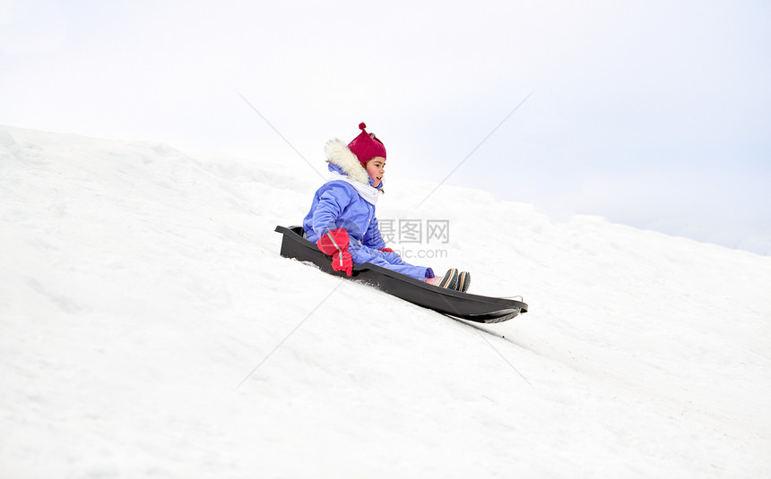 童,雪橇季节的快乐的小女孩滑雪橇下雪山户外冬天快乐的小女孩冬天乘雪橇滑下来图片