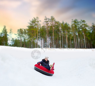 冬天,休闲娱乐活动的快乐的十几岁女孩滑下雪管下山快乐的少女雪管上滑下山背景图片