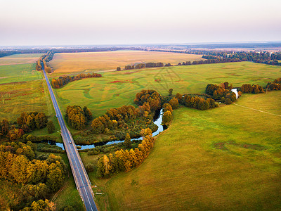 秋晚乡村鸟瞰与河流,小溪,草地,道路农业领域的背景五颜六色的日落秋景图片