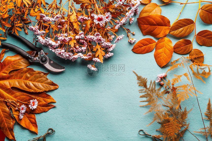 秋季花卉装饰花卉布置背景与黄叶粉红色的花绿松石桌,顶部查看秋季花店工作带的秋季布局框架图片