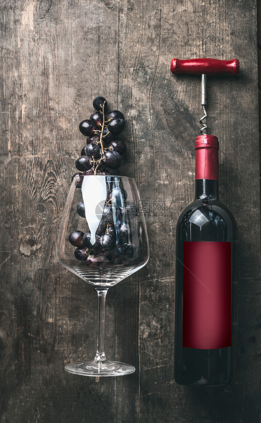 红色酒瓶与老式开瓶器红色模拟标签与葡萄酒璃葡萄乡村木制背景,顶部的视图图片