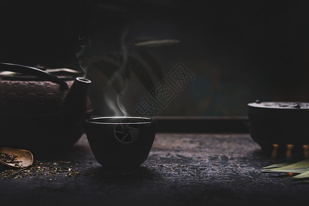 深色茶背景,黑铁亚洲茶壶热茶杯与蒸汽桌子上为您的正宗的复古风格传统的茶道安排背景图片