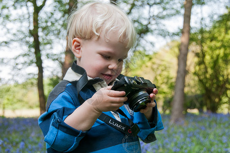 蓝照相机图片带着Lumix相机的孩子,蓝铃木里玩耍背景