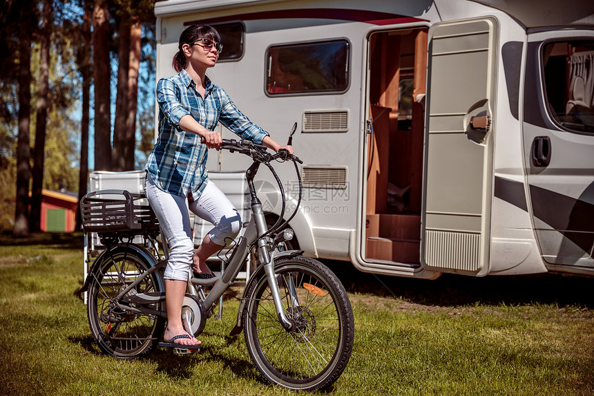 骑电动自行车的女人营地休息家庭度假旅行,汽车度假旅行,商队汽车度假图片