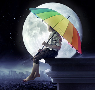 坐在月亮上男孩小男孩着把五颜六色的伞背景