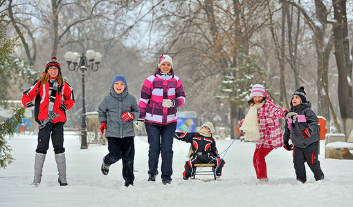 快乐的孩子们冬天公园里玩耍时笑着图片