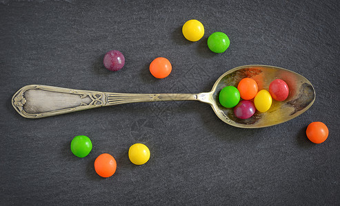 五颜六色的果冻糖果勺子上的阿德西亚盘子图片