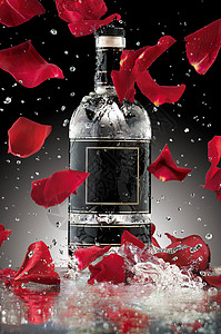 张带掉落玫瑰叶的豪华酒精瓶的照片背景图片