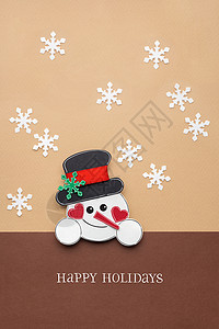 棕色背景上用纸的雪人的创意照片背景图片
