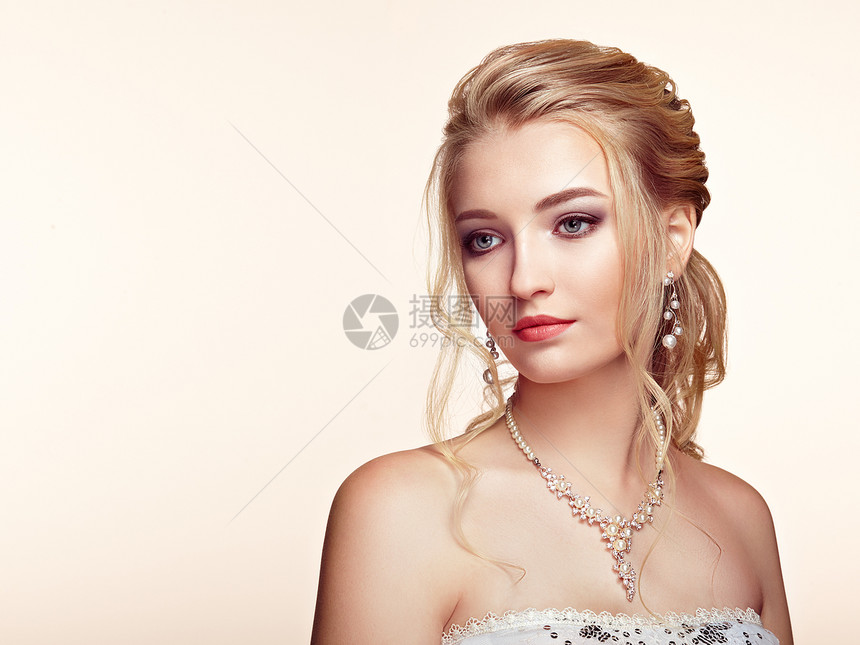 头又长又亮的卷发的金发女孩漂亮的模特,留着卷曲的发型护理美容美发产品完美的化妆珠宝图片