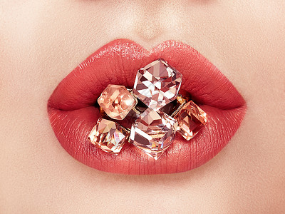 特写美丽的女人嘴唇与红色口红用洁白的牙齿张开嘴巴美容,药店时尚化妆珠宝染色宝石背景图片