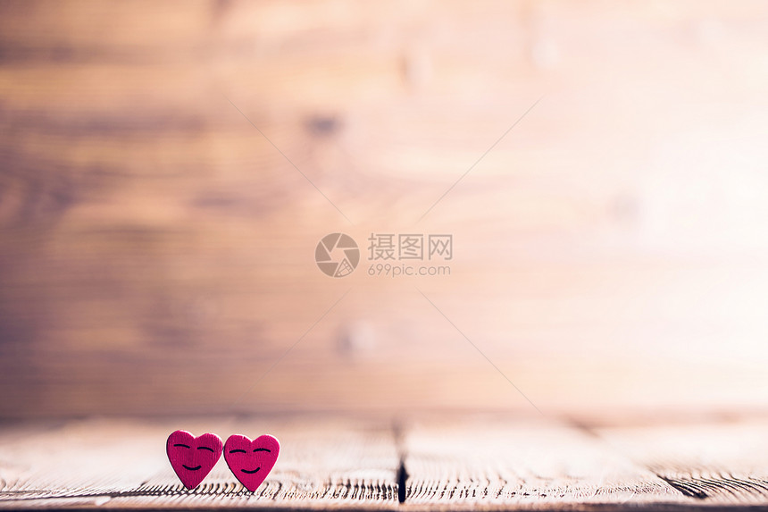 两颗快乐的心两颗粉红色的快乐微笑的心木制的背景上图片